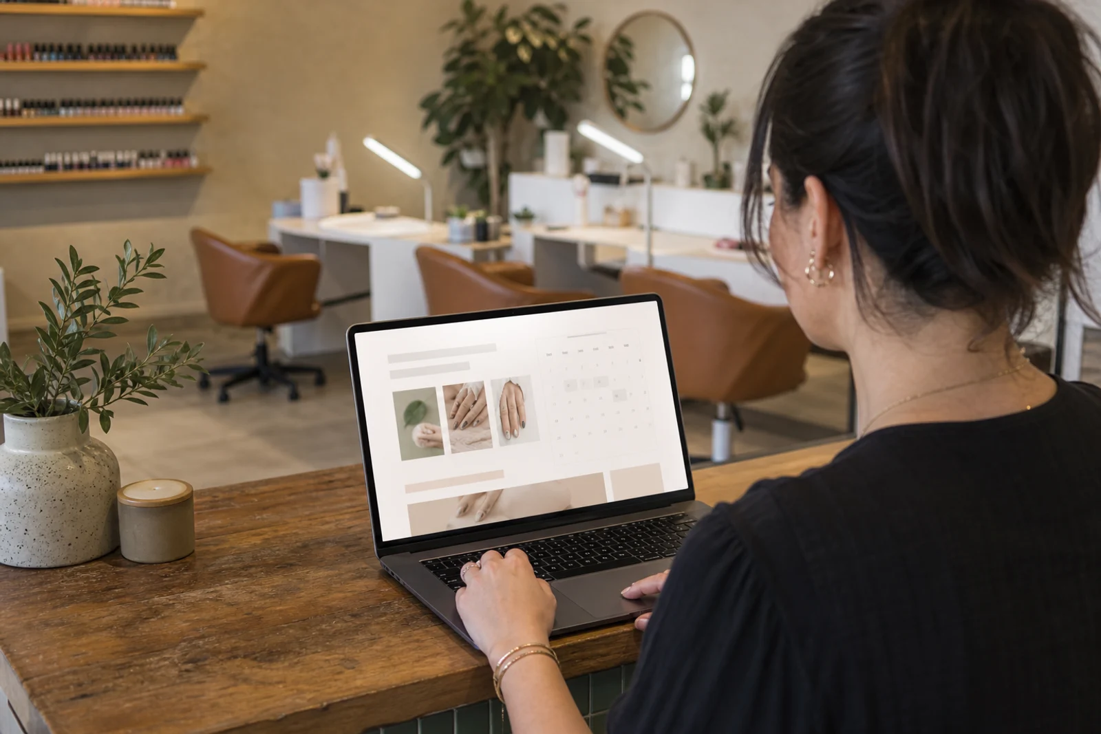 Nail salon owner reviewing a booking-focused website on a laptop